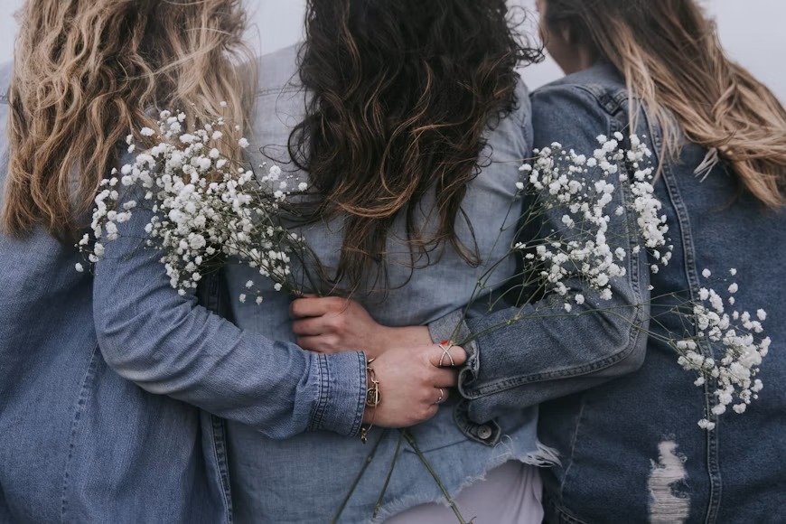 Tres amigas abrazadas con flores de nube